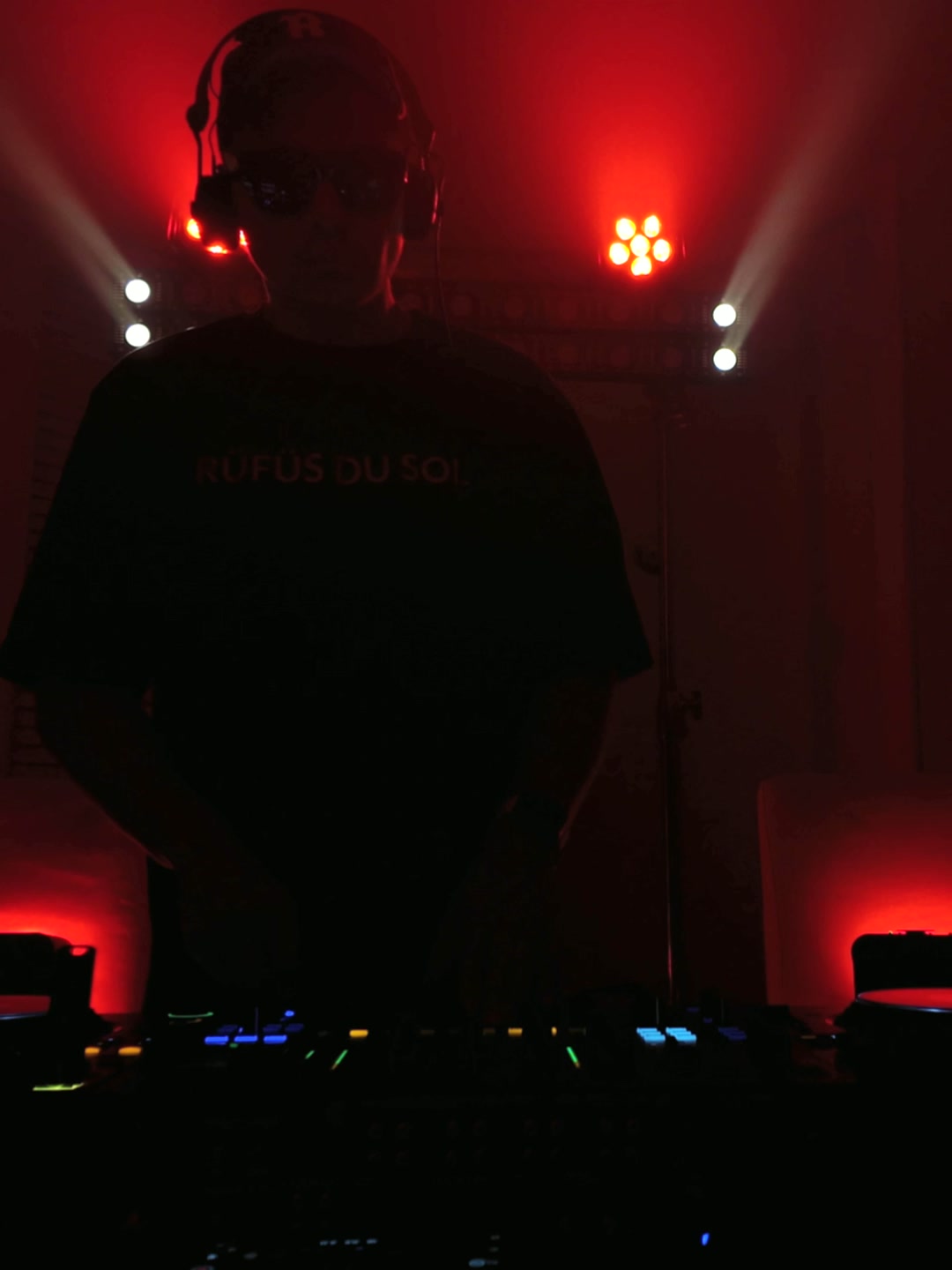 Pauly Cee performing under red lights